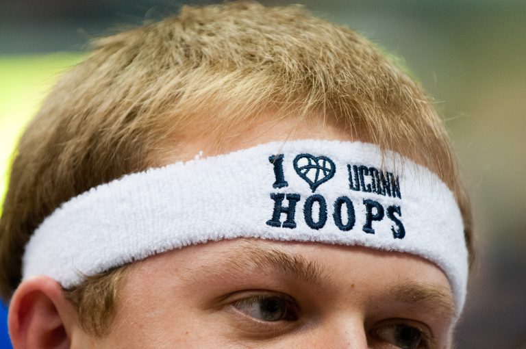 A close-up of a student fan wearing a white headband that says "I love UConn hoops."