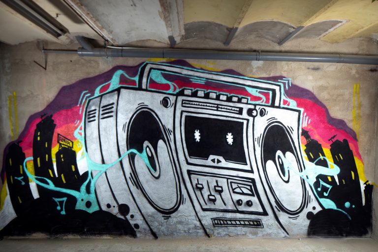 a graffit art work of a boom box ghettoblaster on a wall.