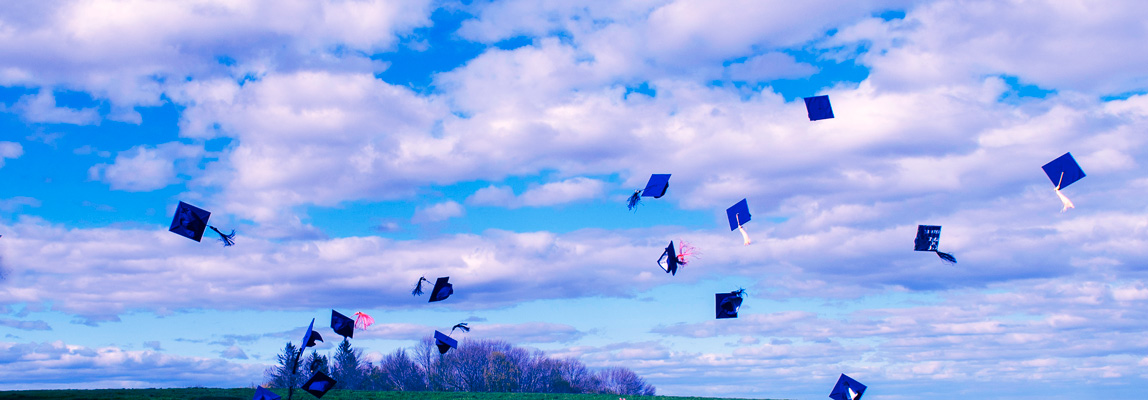 hats170503a052-congrats_vert-bg Graduation caps fly in the air of a blue sky with clouds