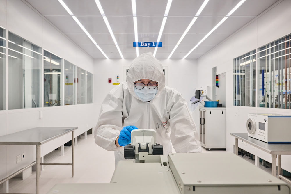 CleanRoom_230626a002 manager, looks though a microscope in a clean room at the Science1 Research Center