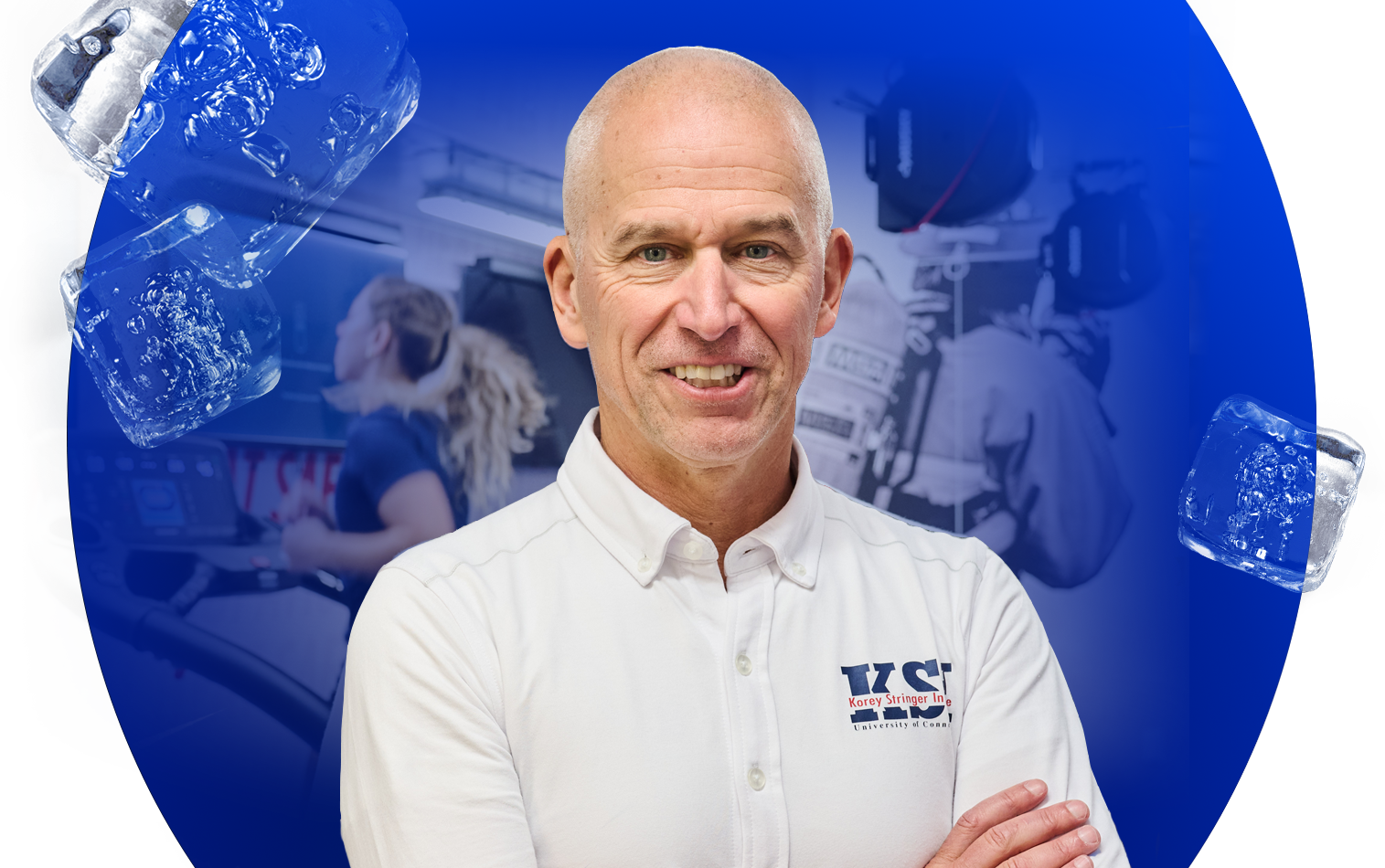 A person wearing a white collared shirt with the logo “KSI” and additional text on the left chest stands in the foreground. The background features a blue gradient with ice cubes on the left side and a blurred scene of people working with technical equipment on the right.