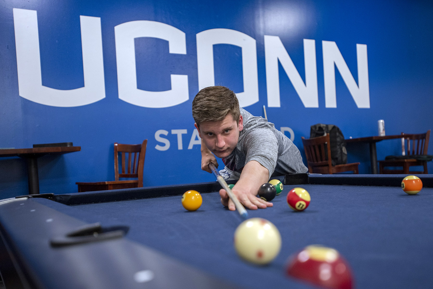 A UConn Stamford student plays pool in the game room.