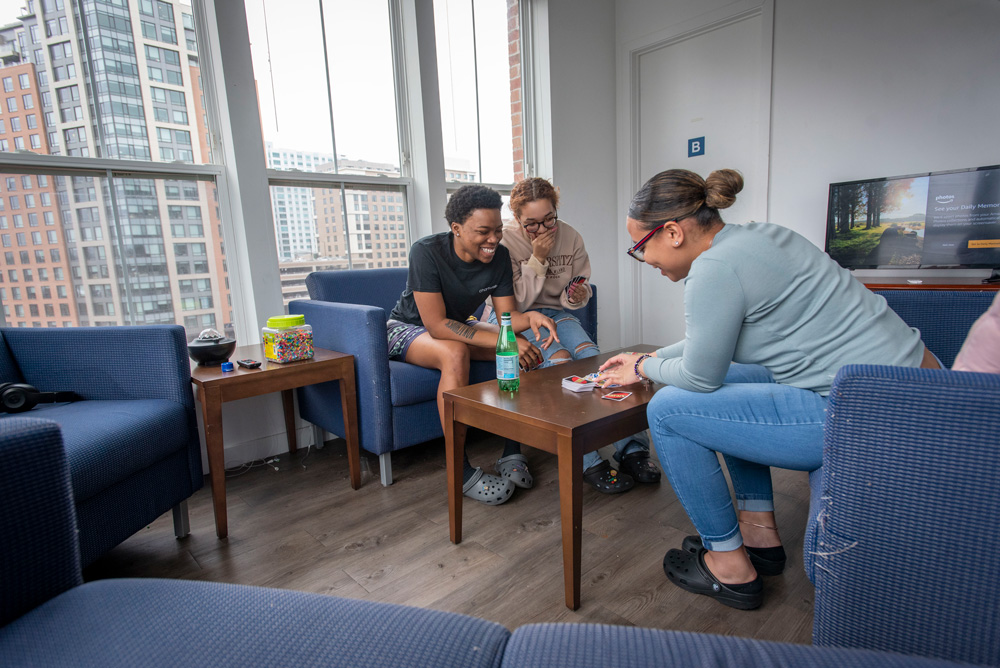 UConn Stamford students in their apartment playing a card game, UNO.