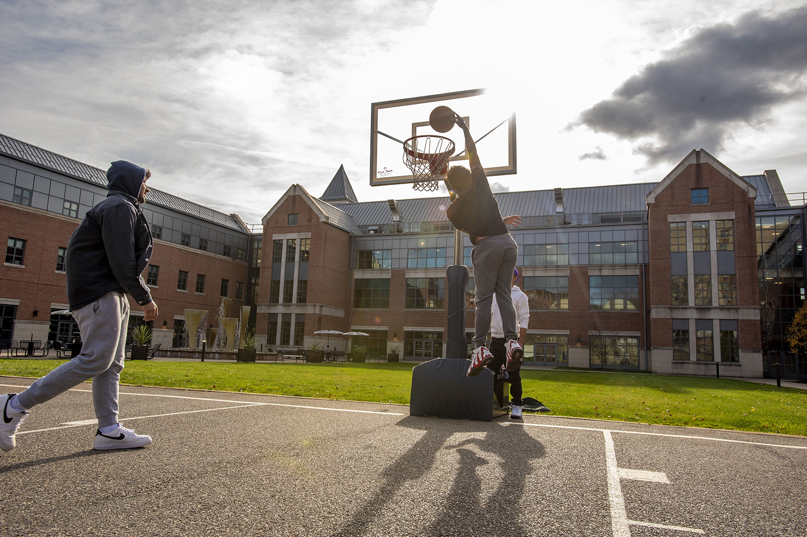 Students play basketball in the UConn Waterbury courtyard