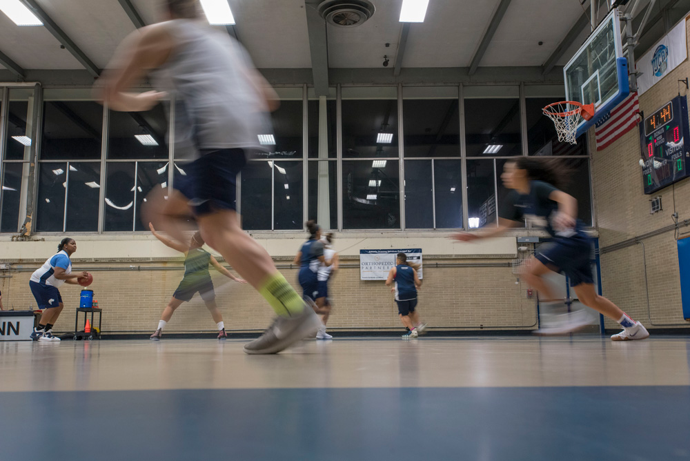 Women playing basketball on indoor court