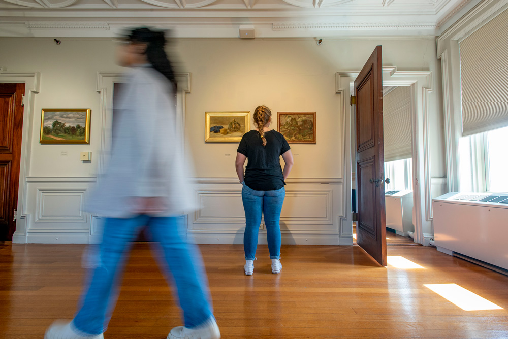 Student looking at artwork in the Alexy von Schlippe Gallery in the Branford House at the Uconn Avery Point campus