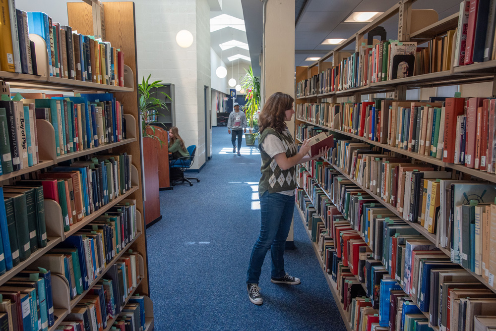 Female student looking at books in the library